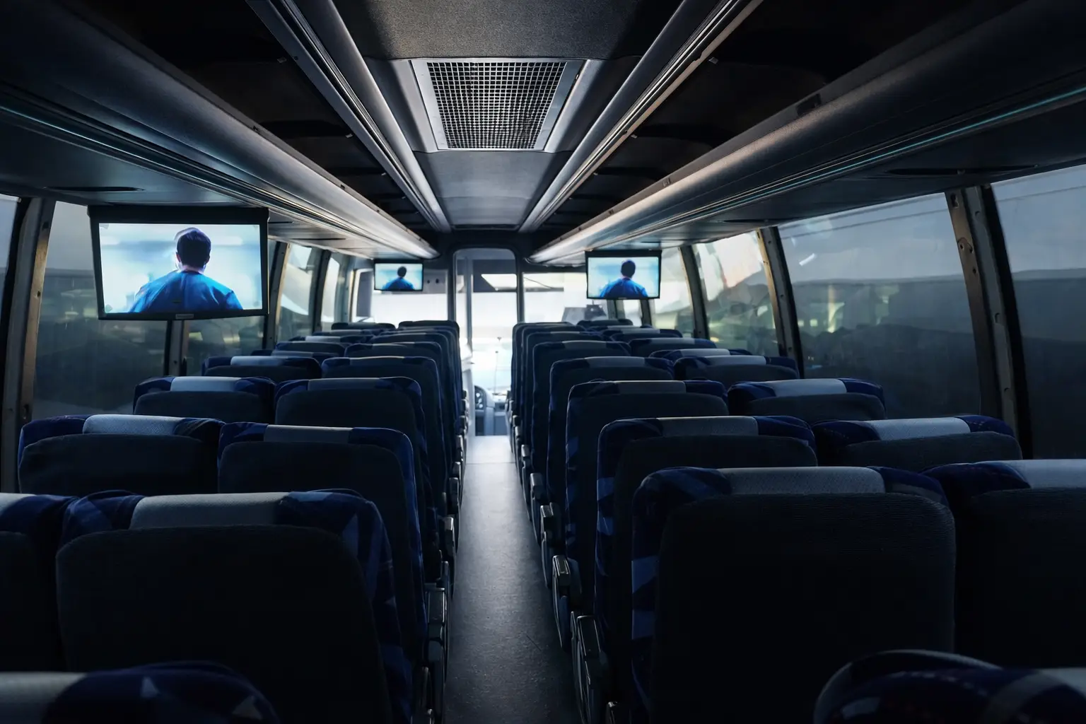 Audio y Video nterior de un autobús de pasajeros equipado con pantallas ambientales laterales que muestran contenido audiovisual, integradas al sistema de entretenimiento a bordo.